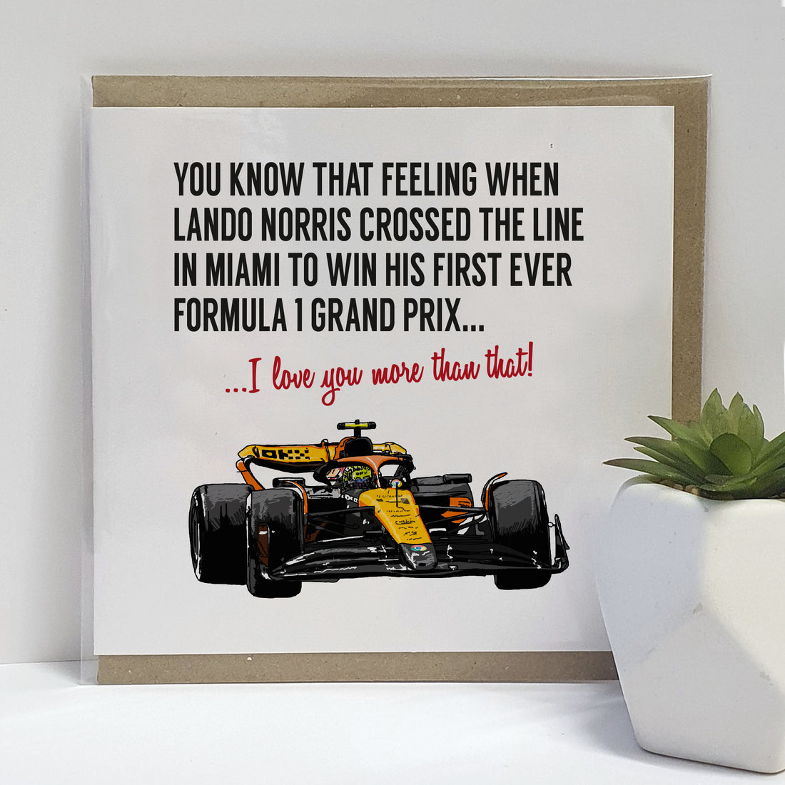 Greeting card featuring an illustration of a Formula 1 car driven by Lando Norris at the moment of his first victory in Miami. The card includes the text 'You know that feeling when Lando Norris crossed the line in Miami to win his first ever Formula 1 Grand Prix... I love you more than that!' Designed by Local Lingo, this card emphasizes the excitement of Formula 1 racing and celebrates a significant moment in the sport.