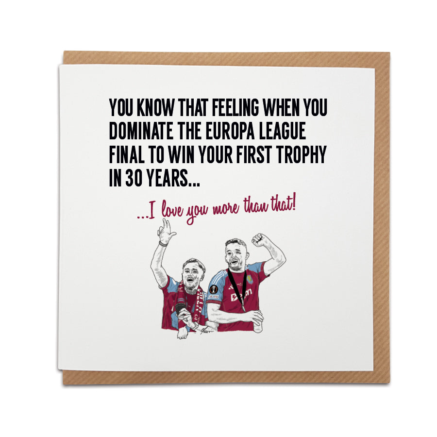 Square romantic greeting card resting on a brown kraft envelope. Bold black text reads "YOU KNOW THAT FEELING WHEN YOU DOMINATE THE EUROPA LEAGUE FINAL TO WIN YOUR FIRST TROPHY IN 30 YEARS..." followed by claret red text reading "...I love you more than that!". Below is a hand drawn illustration of Aston Villa players Matty Cash and John McGinn passionately celebrating in their claret and blue kits. Aston Villa football anniversary card designed by Local Lingo.