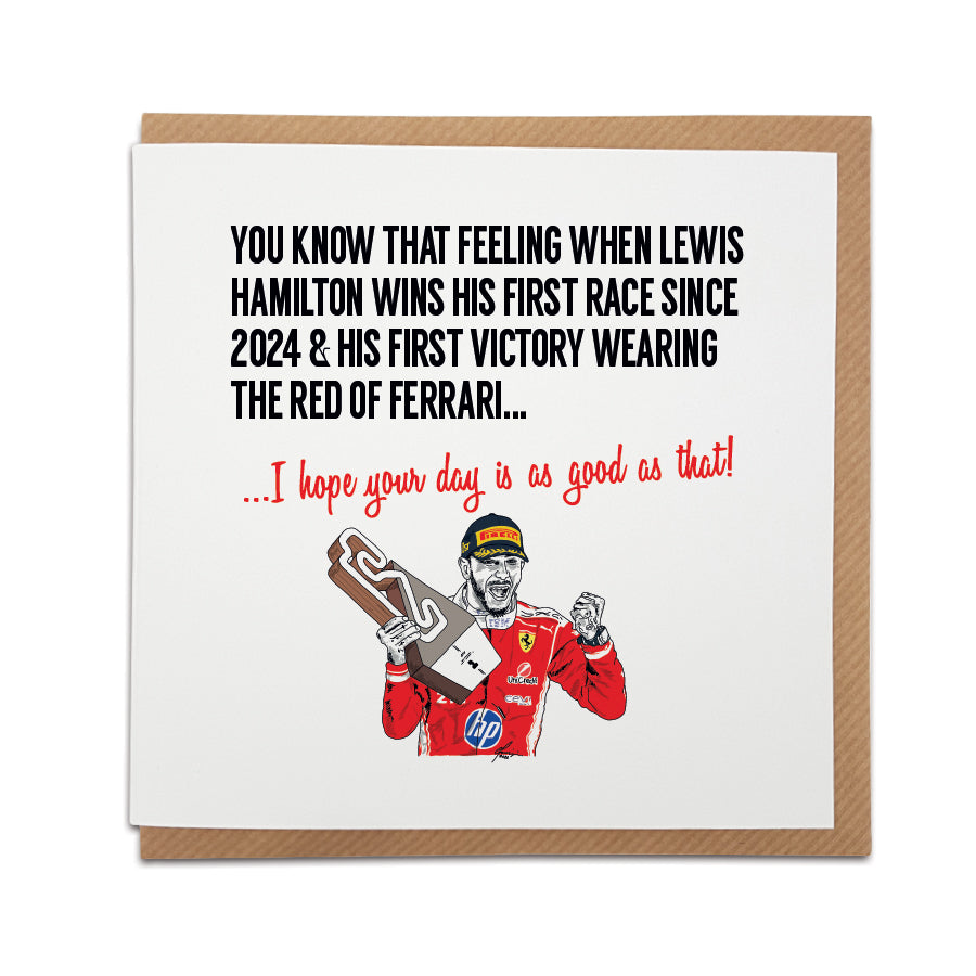 Square birthday greeting card resting on a brown kraft envelope. Bold black text reads "YOU KNOW THAT FEELING WHEN LEWIS HAMILTON WINS HIS FIRST RACE SINCE 2024 & HIS FIRST VICTORY WEARING THE RED OF FERRARI..." followed by red text reading "...I hope your day is as good as that!". Below is a hand-drawn illustration of F1 driver Lewis Hamilton celebrating with a trophy in his red Ferrari race suit. Lewis Hamilton Formula 1 birthday card designed by Local Lingo.