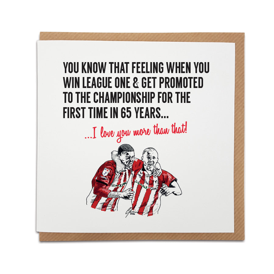 Square greeting card resting on a brown kraft envelope. Bold black text reads: "You know that feeling when you win League One & get promoted to the Championship for the first time in 65 years...". Below it, red script reads "...I love you more than that!". Features a hand-drawn illustration of two football players celebrating in red and white striped kits. Sentimental Lincoln City football fan card, designed by Local Lingo.