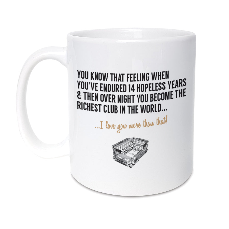 A FUNNY FOOTBALL MUG BASED ON THE NEWCASTLE UNITED TAKEOVER WHICH MAKES THEM THE RICHEST CLUB IN THE WORLD. FEATURES ASN ILLUSTRATION OF ST JAMES PARK AND THE WORDS 'YOU KNOW THAT FEELING WHEN YOU'VE ENDURED 14 HOPELESS YEARS & THEN OVER NIGHT YOU BECOME THE RICHEST CLUB IN THE WORLD,. I LOVE YOU MORE THAN THAT